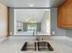 Modern kitchen sink and countertop with a view of the living room through a pass-through window at 2885 Autumn Green Dr, Orlando, FL 32822