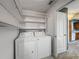 Convenient laundry room featuring a washer, dryer, and ample shelving for storage solutions at 2885 Autumn Green Dr, Orlando, FL 32822