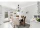 Bright dining area with stylish light fixture, table for four, and doors leading to the outdoor space at 3104 Harrison Ave # E-30, Orlando, FL 32804