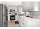 Modern kitchen featuring white cabinetry, stainless steel appliances, quartz countertops, and ample storage space at 3104 Harrison Ave # E-30, Orlando, FL 32804