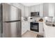 Well-equipped kitchen showcasing stainless steel refrigerator, built-in oven, and sleek white countertops at 3104 Harrison Ave # E-30, Orlando, FL 32804