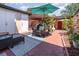 Cozy brick patio with an umbrella, seating, and unique decor elements perfect for outdoor relaxation at 3104 Harrison Ave # E-30, Orlando, FL 32804