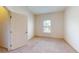 Inviting bedroom with carpeted floor, window, and a door, providing a comfortable space at 3238 Wish Ave, Kissimmee, FL 34747