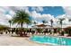 A lagoon style community pool with lounge chairs under wooden pergolas at 3238 Wish Ave, Kissimmee, FL 34747