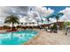 Community pool with palm trees and lounge chairs under wooden pergolas at 3238 Wish Ave, Kissimmee, FL 34747