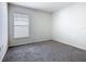 A cozy bedroom features a large window and plush gray carpeting at 408 Lily Ln, Davenport, FL 33837