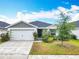 Charming one-story home features a two-car garage, manicured lawn, and beautiful landscaping at 408 Lily Ln, Davenport, FL 33837