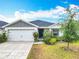 Inviting one-story home with a well-manicured lawn, two car garage and a green front door at 408 Lily Ln, Davenport, FL 33837