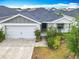 Charming one-story home with a well-manicured lawn, two car garage and welcoming entrance at 408 Lily Ln, Davenport, FL 33837