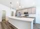 Bright kitchen features gray cabinets, stainless appliances, an island with a sink, and modern pendant lighting at 408 Lily Ln, Davenport, FL 33837