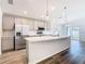 Bright kitchen features gray cabinets, stainless appliances, an island with a sink, and modern lighting at 408 Lily Ln, Davenport, FL 33837