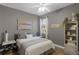 Comfortable bedroom with soft bedding, decorative wall art, and plenty of natural light from the window at 413 Macchi Ave, Oakland, FL 34787