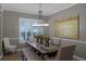 Cozy dining area illuminated by a linear chandelier, complemented by a large canvas and shuttered windows at 413 Macchi Ave, Oakland, FL 34787