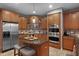 Gourmet kitchen boasts stainless steel appliances, center island with seating and wood cabinetry at 413 Macchi Ave, Oakland, FL 34787