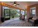 Relaxing screened patio with wicker furniture, ceiling fan, and a view of the lush backyard at 413 Macchi Ave, Oakland, FL 34787