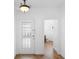 Bright entryway features a glass-paneled front door, hardwood floors, and access to the half-bathroom at 456 Harbor Winds Ct, Winter Springs, FL 32708