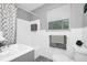 Bright bathroom with a shower-tub combo, window for natural light, and ample towel storage at 511 S Alder Ave, Orlando, FL 32807