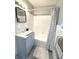 This renovated bathroom includes a tub with shower and designer gray vanity at 511 S Alder Ave, Orlando, FL 32807