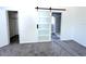 Bright bedroom featuring neutral carpet, closet, and a modern sliding barn door to bath at 511 S Alder Ave, Orlando, FL 32807