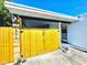 Charming home featuring a private, gated front entry and vibrant yellow wood fence with an inviting walkway to the front door at 511 S Alder Ave, Orlando, FL 32807