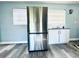 Bright kitchen featuring stainless steel refrigerator, white cabinets, granite countertops, and gray wood flooring at 511 S Alder Ave, Orlando, FL 32807