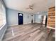 Open living room with wood-look flooring, ceiling fan, stainless refrigerator and modern design elements at 511 S Alder Ave, Orlando, FL 32807