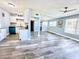 Spacious living room featuring stylish gray flooring, a ceiling fan, and abundant natural light from the many windows at 511 S Alder Ave, Orlando, FL 32807