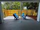 Outdoor patio with blue Adirondack chairs, a wooden fence, and space for entertaining at 511 S Alder Ave, Orlando, FL 32807