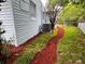 Side yard with mulch path, fence, and view of the light blue siding and AC unit at 511 S Alder Ave, Orlando, FL 32807