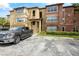 Inviting multi-story condo building featuring manicured landscaping, pergola and ample parking spaces on a sunny day at 5156 Conroy Rd # 1124, Orlando, FL 32811