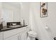 A modern bathroom featuring a dark countertop with dual sinks, white cabinets, and neutral wall decor at 5248 Royal Point Ave, Kissimmee, FL 34746