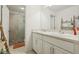 Bathroom featuring a dual-sink vanity with white cabinets, white countertops, and a glass-enclosed walk-in shower at 5248 Royal Point Ave, Kissimmee, FL 34746
