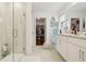 Bright bathroom with double sinks, a glass-enclosed shower, and a walk-in closet nearby at 5248 Royal Point Ave, Kissimmee, FL 34746