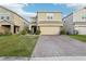 Two-story home features a brick driveway, a two-car garage, and well-maintained landscaping at 5248 Royal Point Ave, Kissimmee, FL 34746