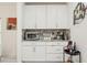 A bar area with white cabinets, granite counters, and a coffee station is perfect for hosting and entertaining at 5248 Royal Point Ave, Kissimmee, FL 34746