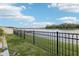 Scenic view of the lake with well manicured lawn and black iron fence at 5248 Royal Point Ave, Kissimmee, FL 34746