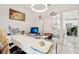 Bright office with a large white desk, stylish lighting, and views into another room via glass-panel French doors at 5248 Royal Point Ave, Kissimmee, FL 34746