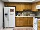 Functional kitchen with oak cabinets, white appliances, and a tile backsplash, blending style and practicality at 567 E Orange St # 567, Altamonte Springs, FL 32701