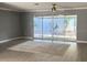 Open living room with gray walls, light wood floors, and sliding glass doors offering natural light and easy access to outside at 567 E Orange St # 567, Altamonte Springs, FL 32701