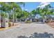 Gated community entrance with lush landscaping and mature trees offers security and curb appeal at 6142 Westgate Dr # 204, Orlando, FL 32835