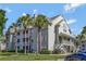 Inviting condo complex with tropical palm trees, lush green lawn, and ample parking at 6142 Westgate Dr # 204, Orlando, FL 32835