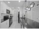 A kitchen with modern appliances, a sleek countertop, and a contemporary lighting fixture at 6142 Westgate Dr # 204, Orlando, FL 32835