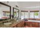 Bathroom featuring double sinks, tile floors, and a tub with views of the lake at 645 Manor Rd, Maitland, FL 32751