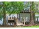 Charming dock features a boathouse, wood walkway, and serene lakefront setting amidst lush greenery at 645 Manor Rd, Maitland, FL 32751