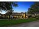 Elegant home featuring a grand facade, manicured lawn, arched windows, and lush landscaping at 645 Manor Rd, Maitland, FL 32751