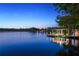 Scenic lake view featuring a private boat dock and covered seating area with lighting at twilight at 645 Manor Rd, Maitland, FL 32751