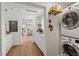 Bright laundry room with stacked washer/dryer and adjacent sink with stone countertops at 645 Manor Rd, Maitland, FL 32751