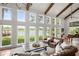 Bright living room with beamed ceilings and many windows that overlook the lake at 645 Manor Rd, Maitland, FL 32751