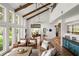 Bright living room features beamed ceilings, brick flooring, and large windows overlooking greenery at 645 Manor Rd, Maitland, FL 32751