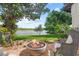 Inviting patio with stone fire pit, chairs, and verdant landscaping offers serene waterfront views at 645 Manor Rd, Maitland, FL 32751